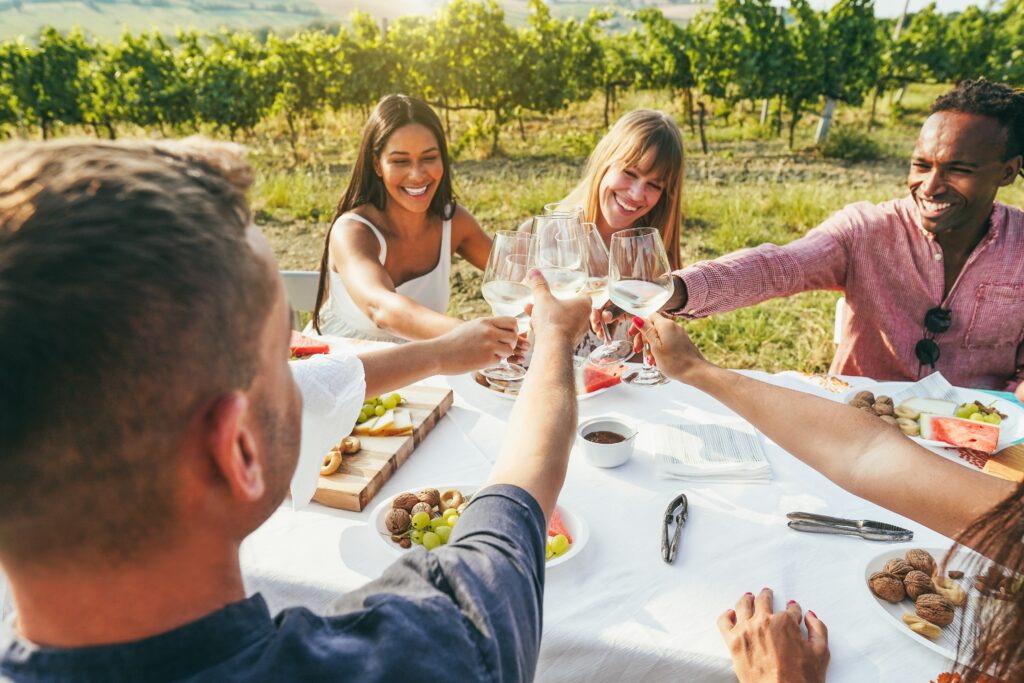 Diverse group enjoying white wine at a vineyard table